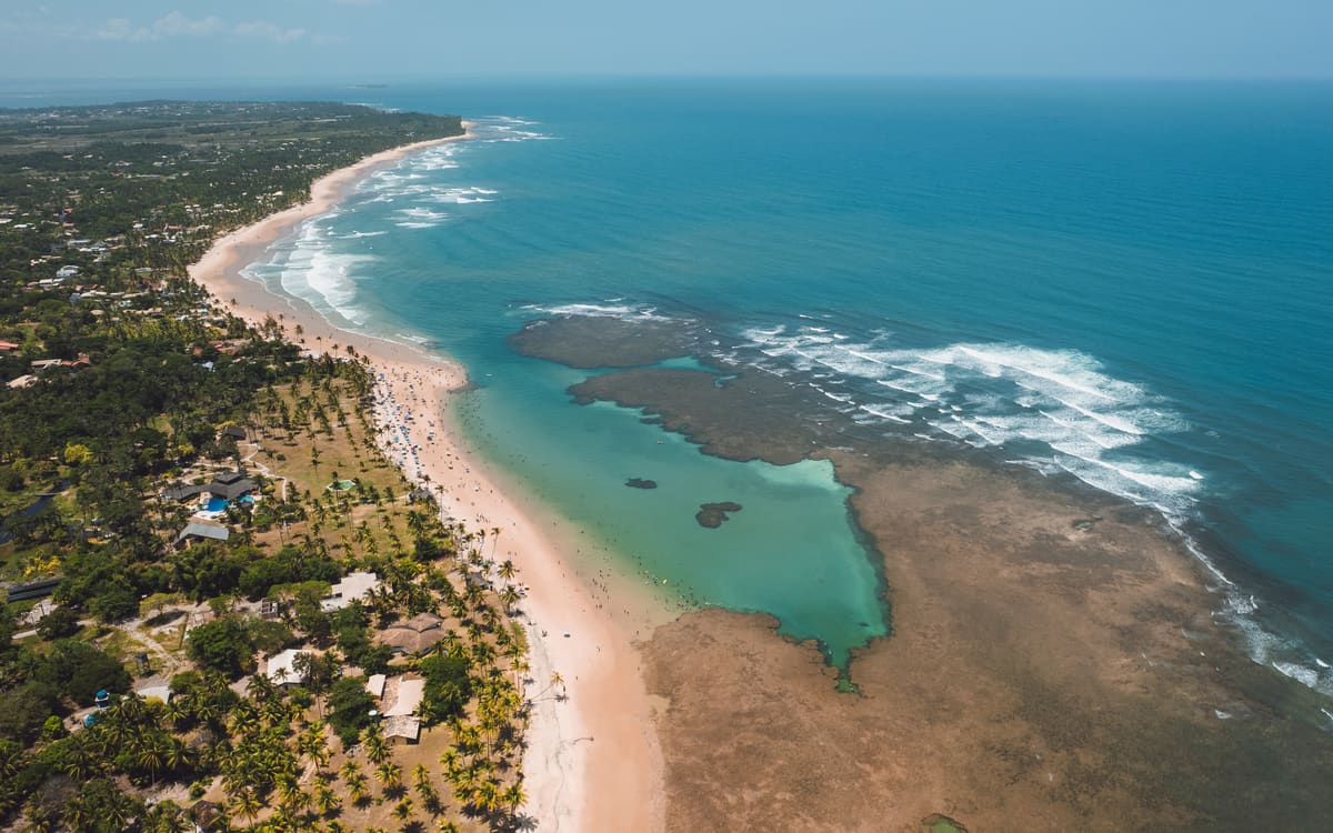 Vista aérea das piscinas naturais de Taipu de Fora com o recife exposto na maré baixa.